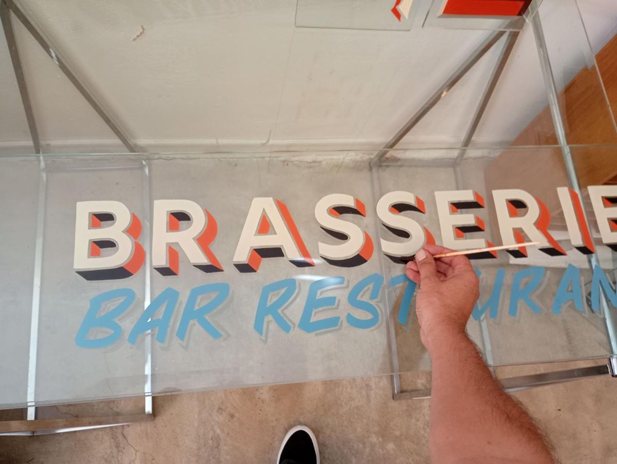 Lettrage « Brasserie – Bar Restaurant » en cours : relief et ombres portées au pinceau