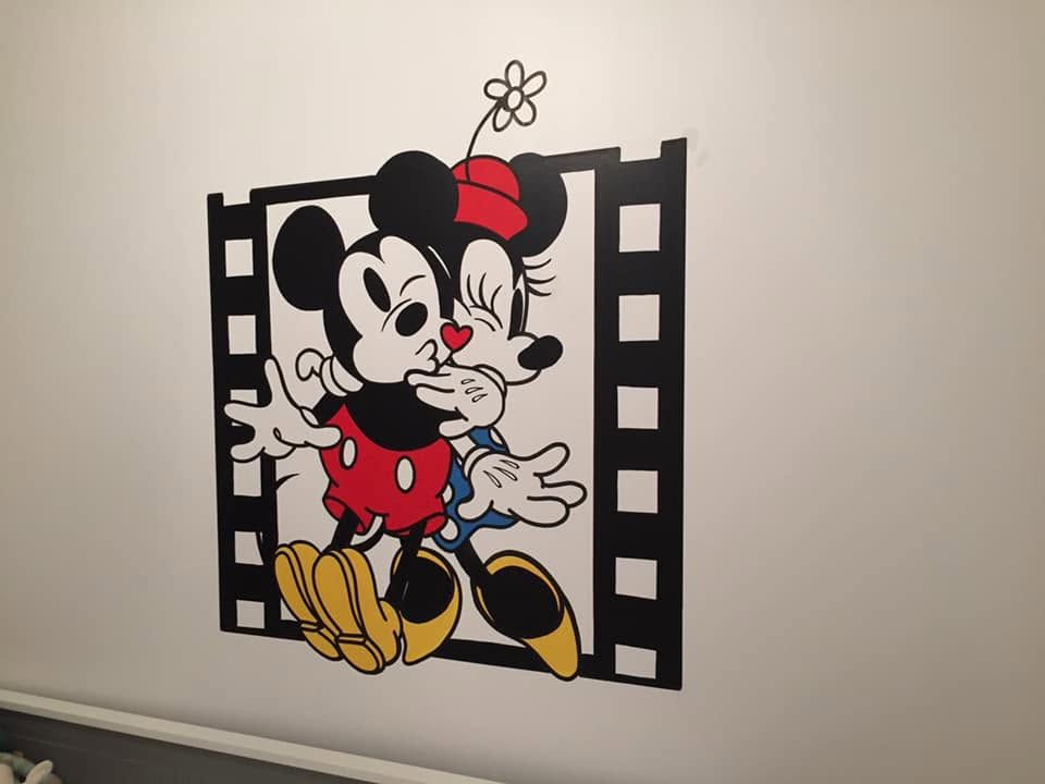 Mickey et Minnie s'embrassant dans une pellicule de cinéma, peints sur un mur de chambre