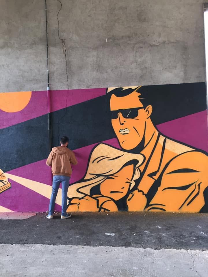 Détail de la fresque : un homme à lunettes noires tenant une jeune femme endormie, Raphaël au pied du mur