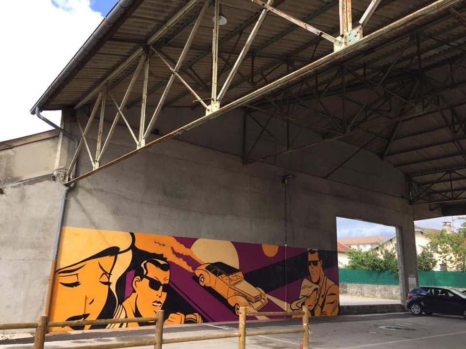 La fresque vue de biais sous la charpente métallique du parking couvert