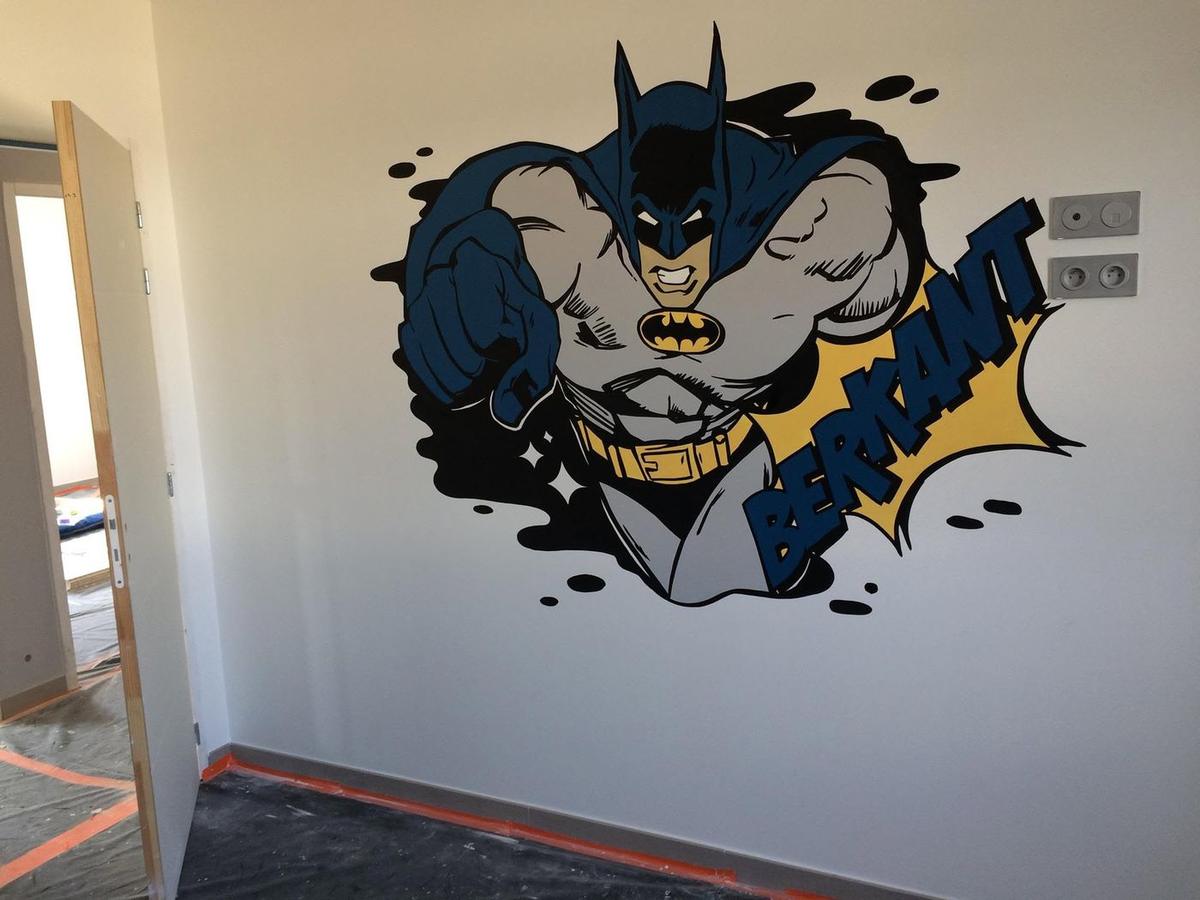 Batman surgissant du mur, poing en avant, avec un prénom en lettres de bande dessinée
