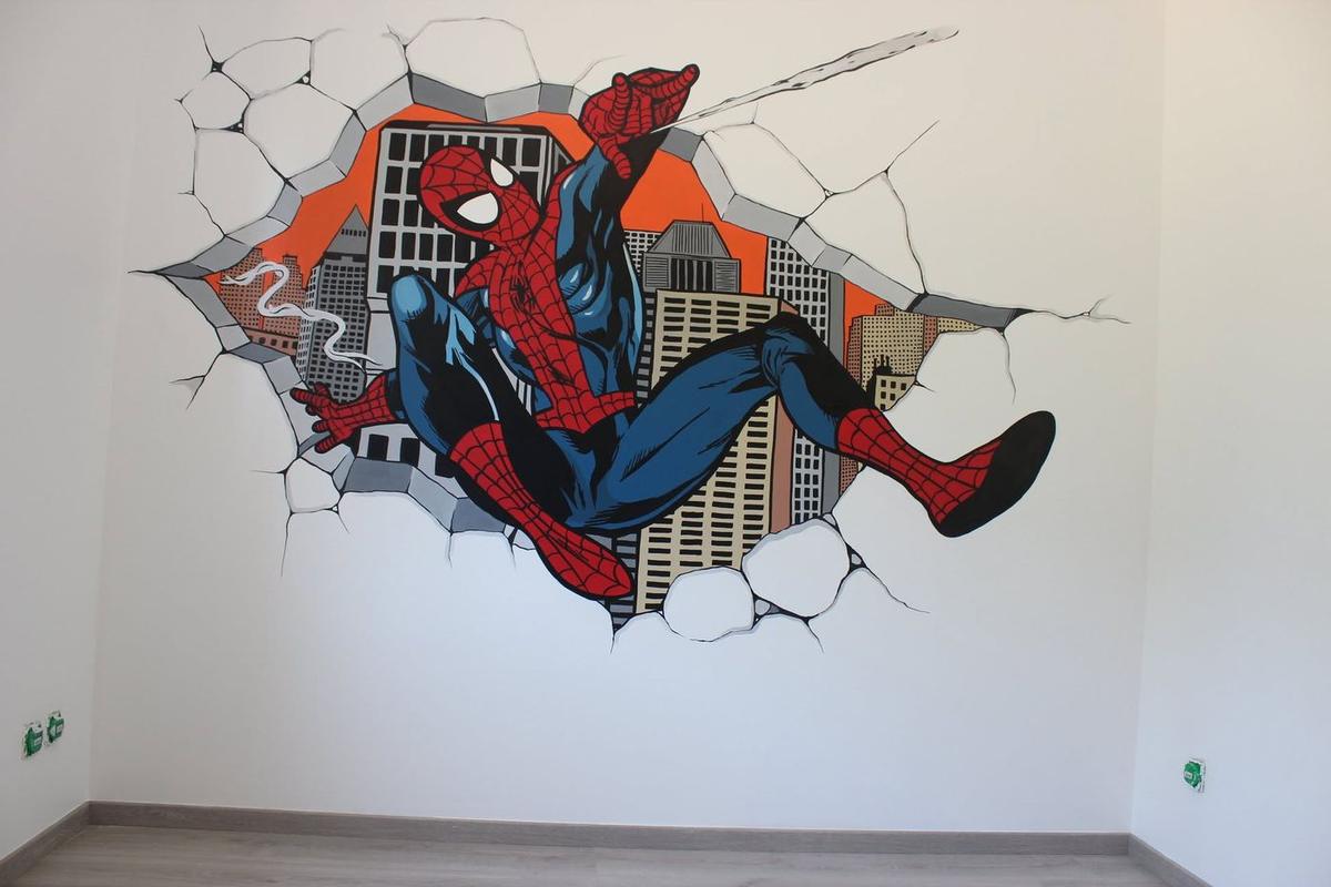 Fresque de Spider-Man terminée, jaillissant d'un mur brisé devant des gratte-ciel sur fond orange
