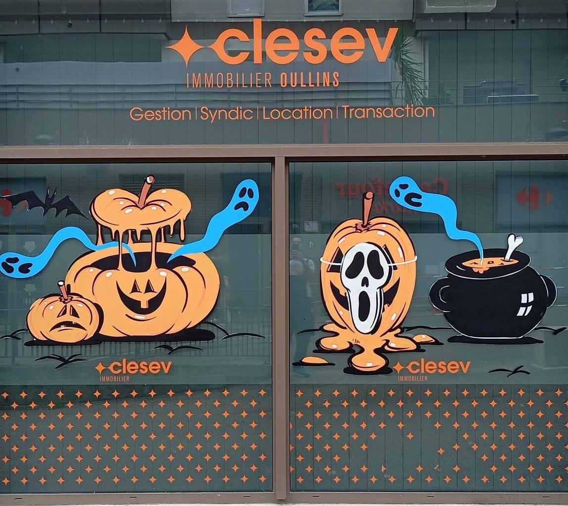 Façade de l'agence immobilière Clesev à Oullins décorée pour Halloween : citrouilles, fantômes bleus, citrouille masquée et chaudron