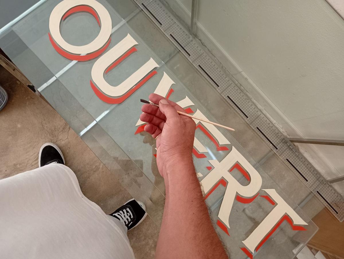 Lettres « Ouvert » à empattements avec ombre rouge, peintes au pinceau