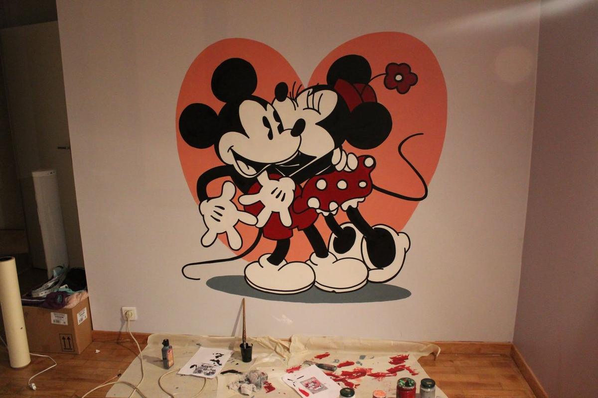 Mickey et Minnie enlacés devant un grand cœur rose, peints sur le mur d'une chambre