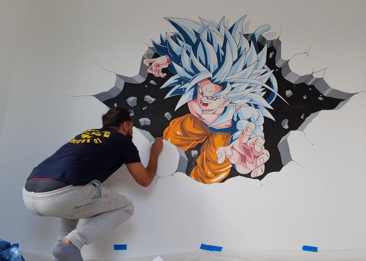Raphaël en train de peindre une fresque de Goku jaillissant d'un mur brisé