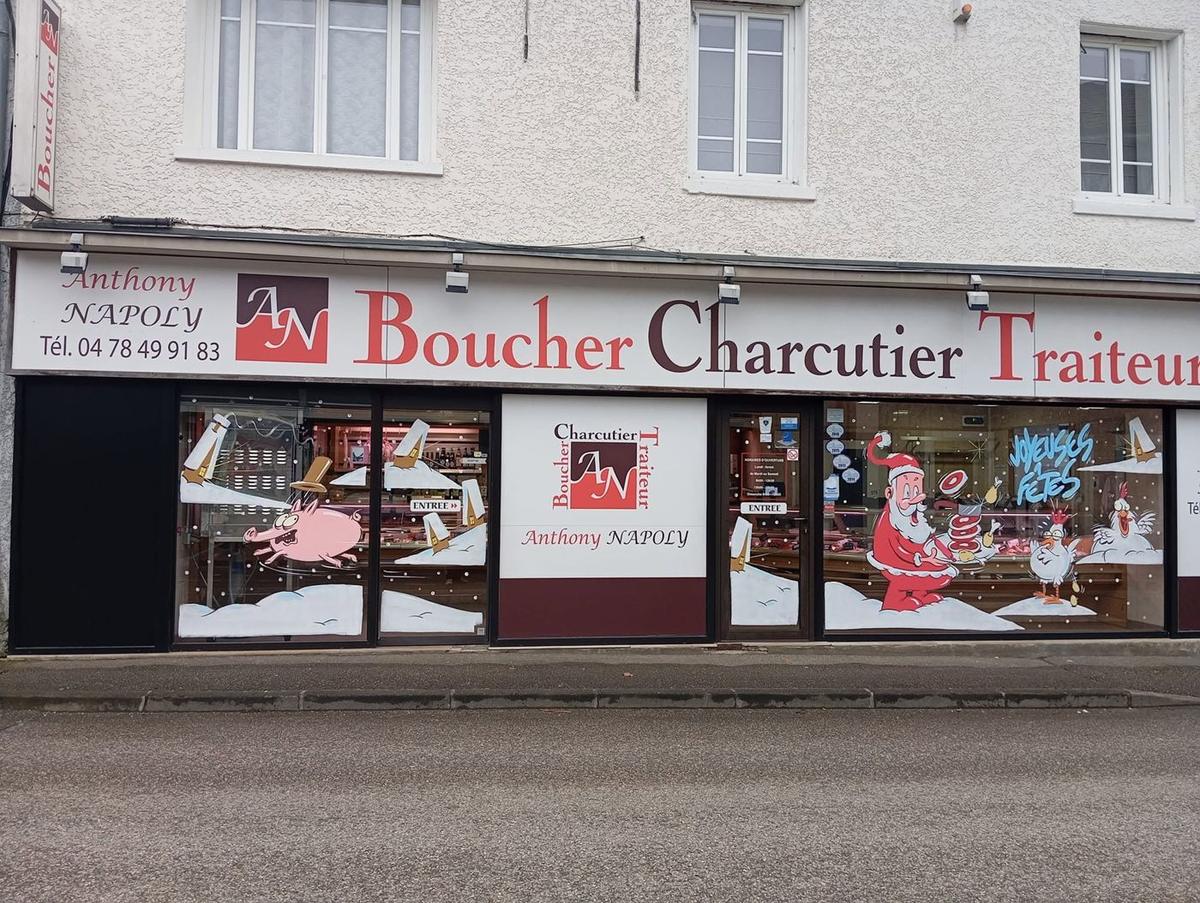 Toute la devanture de la boucherie décorée : cochon qui s'enfuit, maisons enneigées, Père Noël et poules