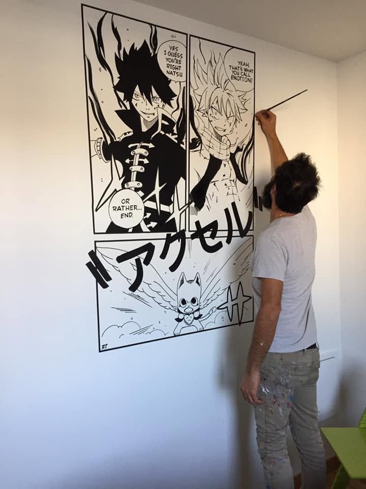 Raphaël peignant une planche de manga Fairy Tail en noir et blanc sur un mur de chambre