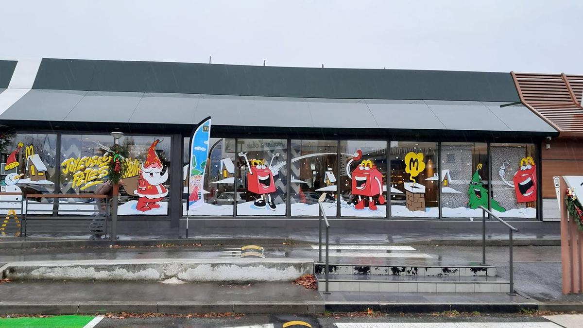 Toute la façade du restaurant McDonald's décorée : une dizaine de vitrines peintes sur le thème de Noël