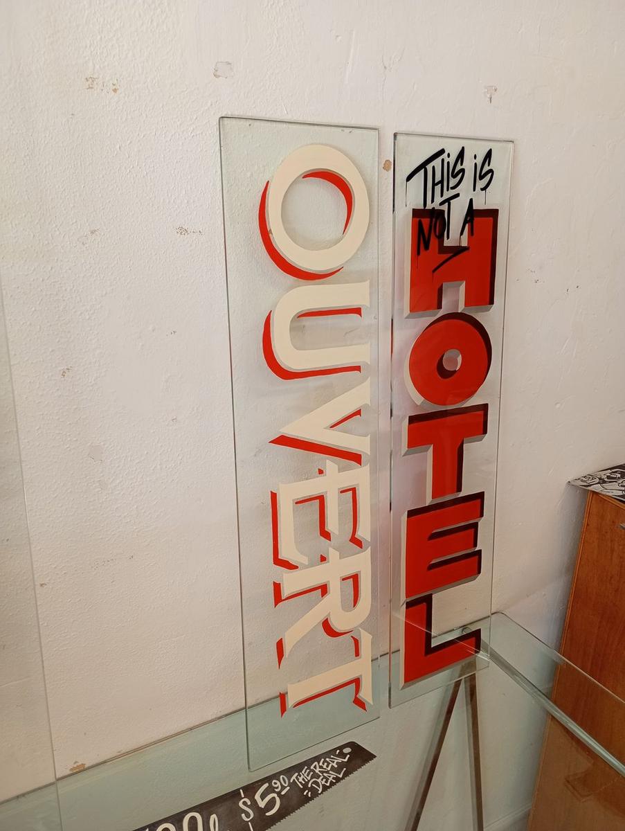 Panneaux « Ouvert » et « This is not a Hotel » peints sur verre, deux styles de lettres